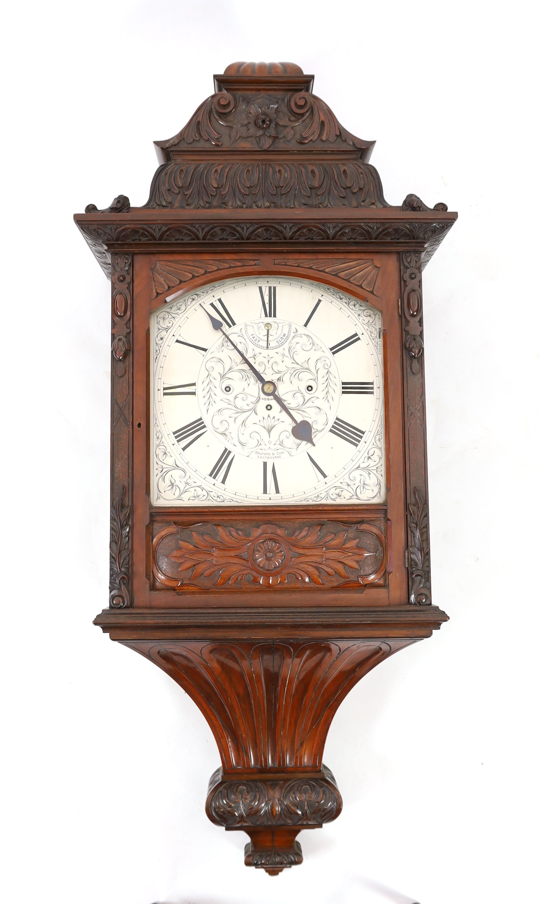 A large and impressive early 20th century carved mahogany cased wall clock, the triple fusee movement striking on a cluster of eight bells and five gongs, the 39cm engraved arched silvered dial with fast / slow select ma